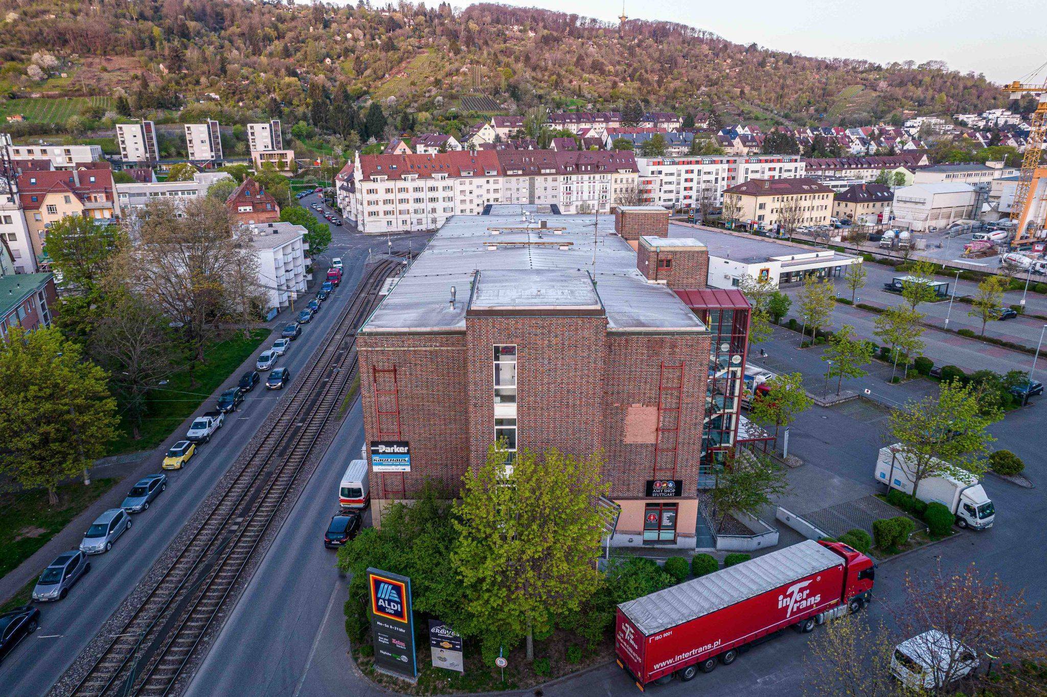 Ein Gebäude mit vielen Autos und einer Straße mit Bäumen, aufgenommen mit Techniken der Immobilienfotografie.