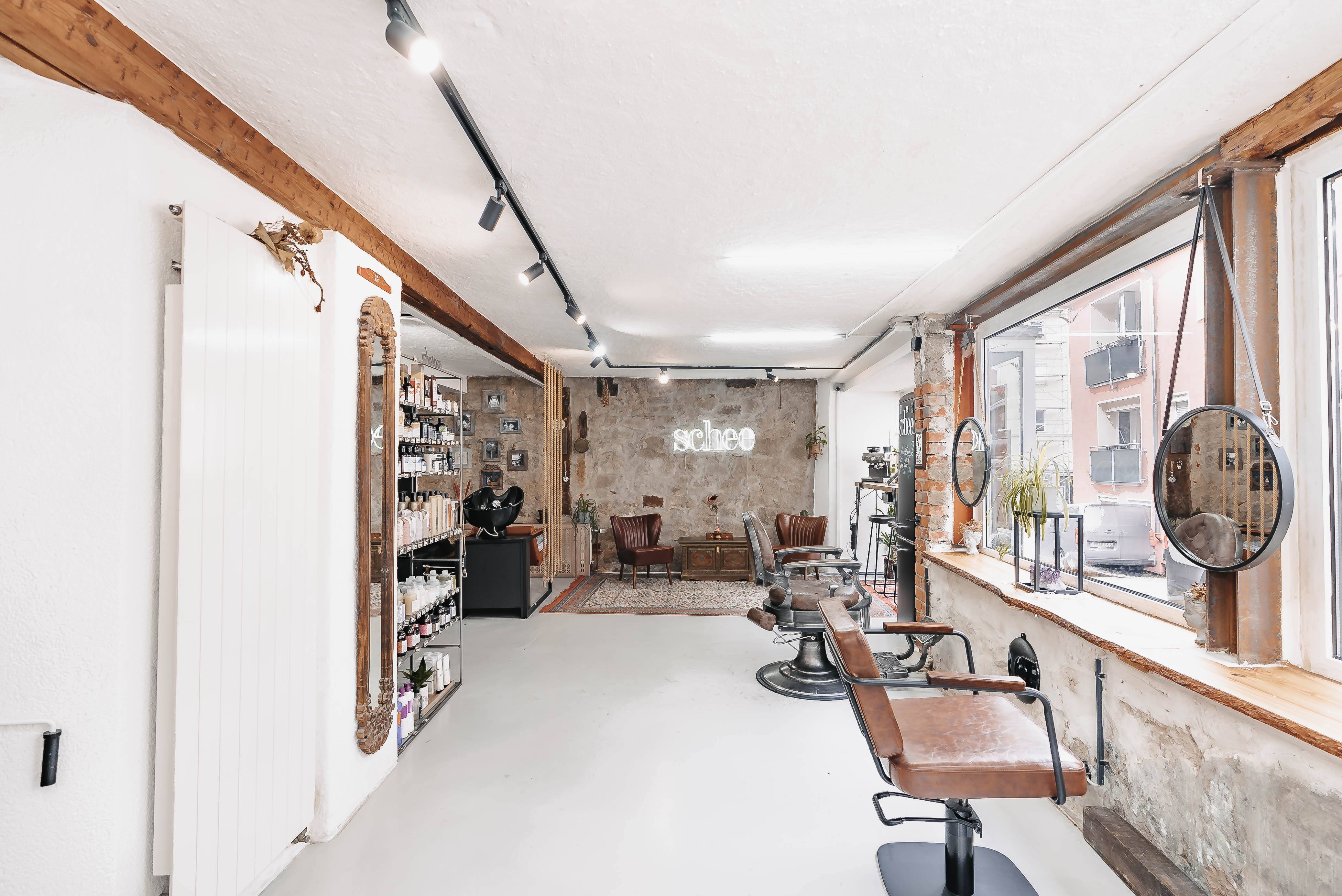 Ein Friseursalon mit modernen Stühlen und einem großen Fenster, wunderschön eingefangen durch die Linse von Immobilien Fotograf Stuttgart