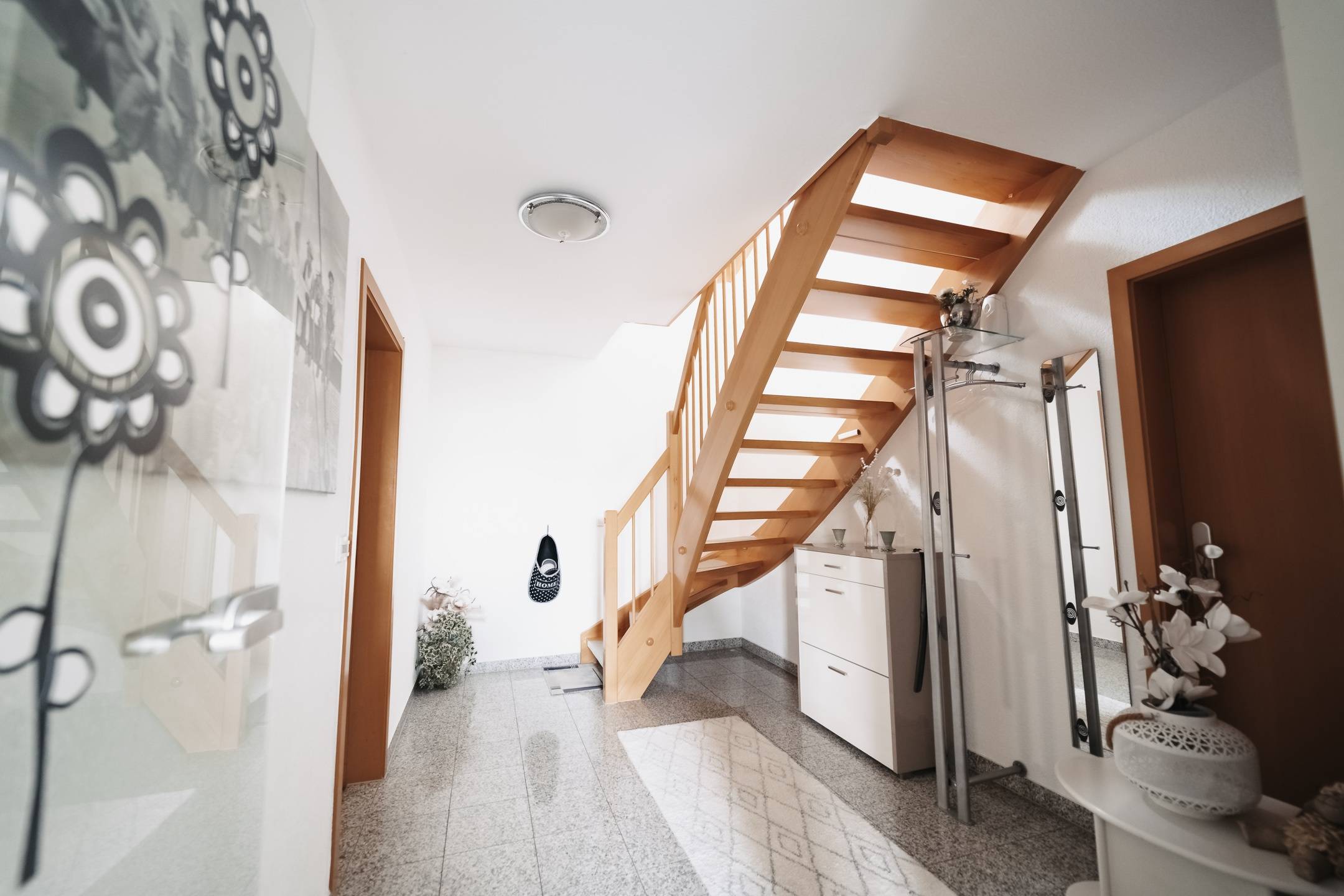 Das Bild eines Flurs mit Holztreppe zeigt exquisite Immobilienfotografie. Immobilien Fotograf Stuttgart